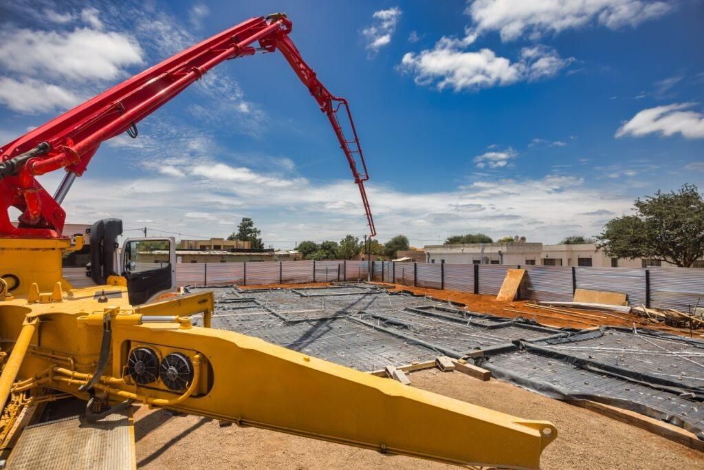 A Concrete Pump Truck Is Pouring Concrete On A Construction Site — Lonnie Henderson Concreting In Kurri Kurri, NSW