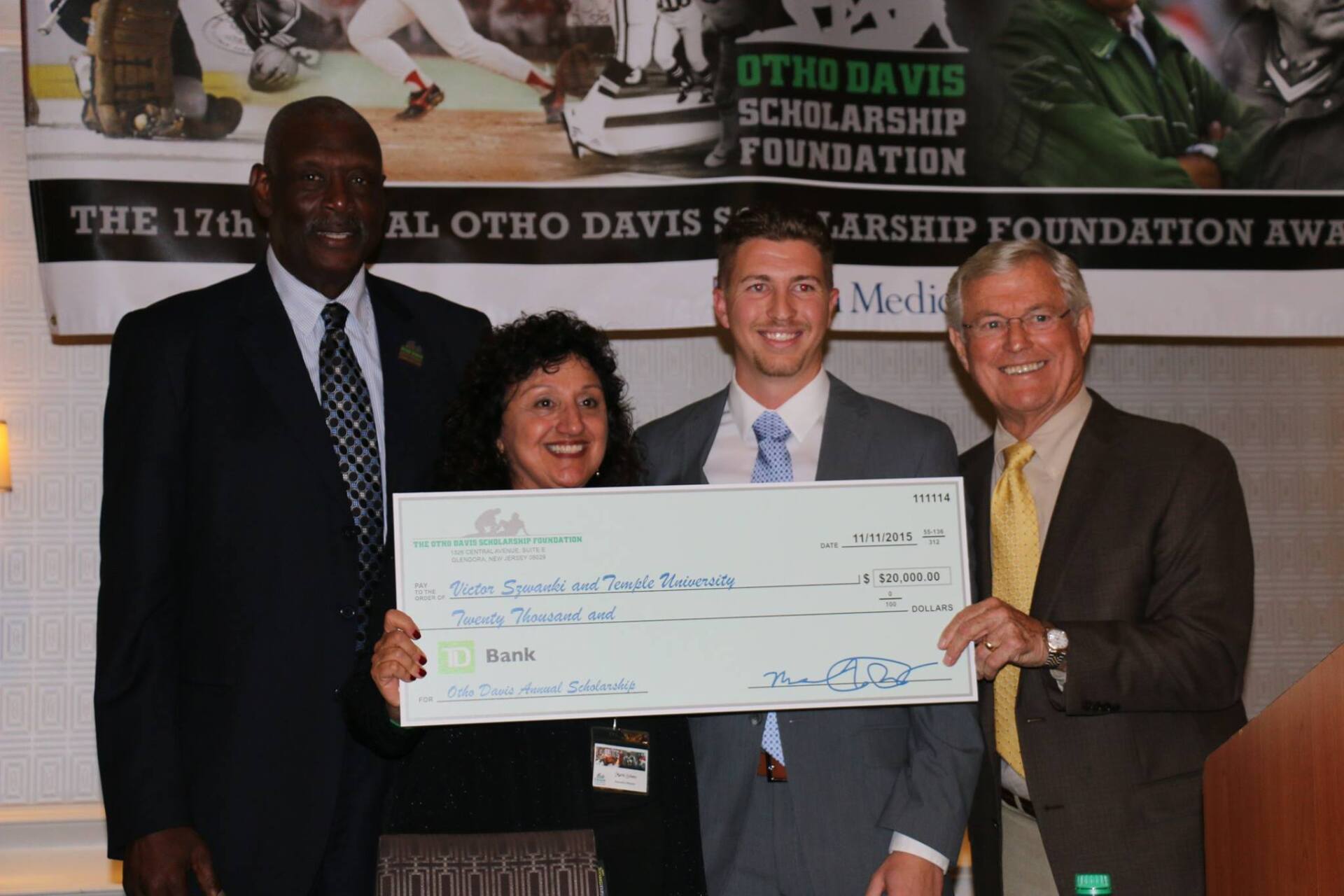 A group of people holding a check in front of a sign that says the 17th al otho davis scholarship foundation