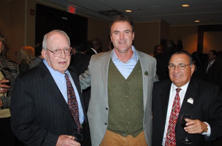 Three men in suits and ties pose for a picture