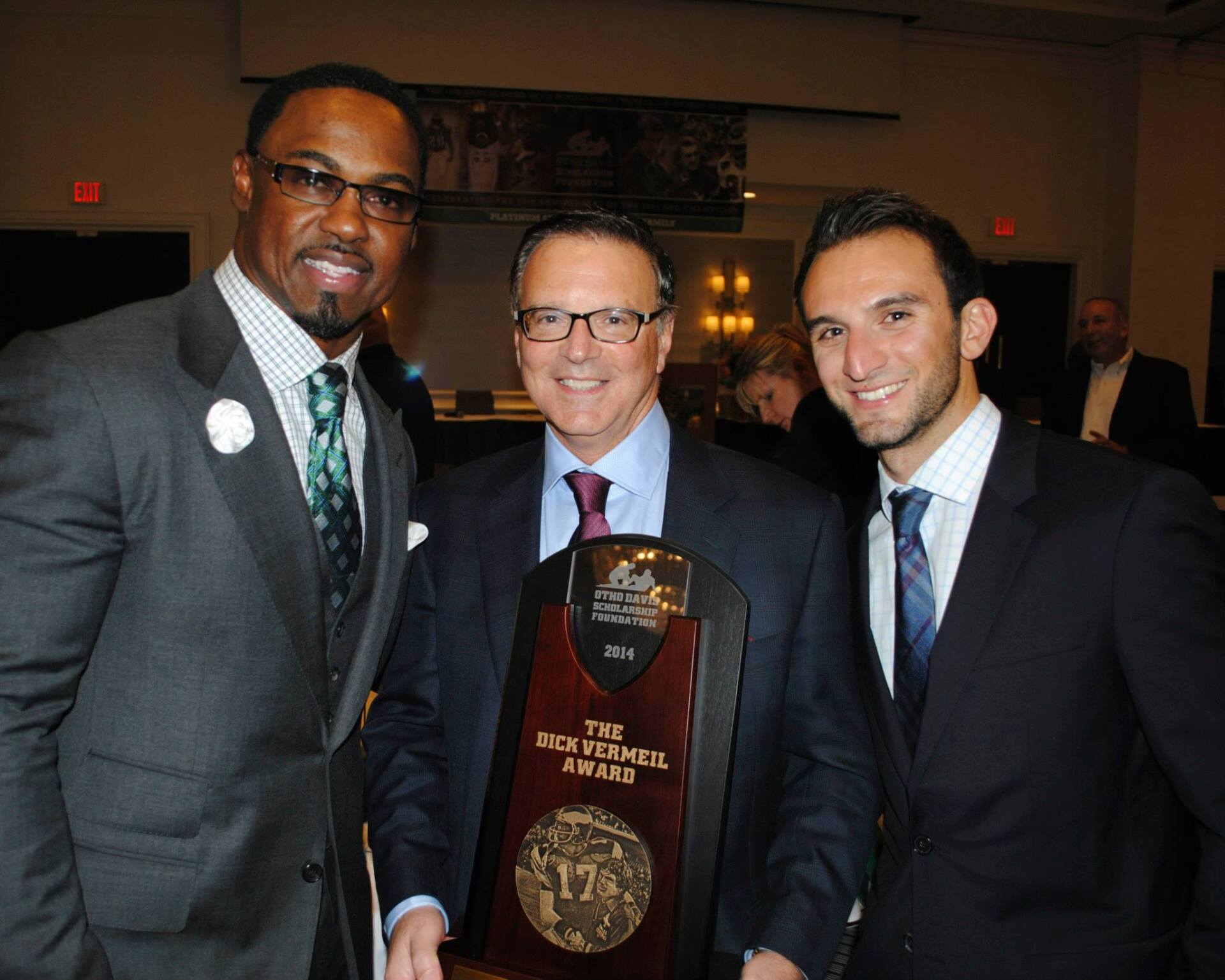 Three men are posing for a picture with a trophy that says the rich f. smith award