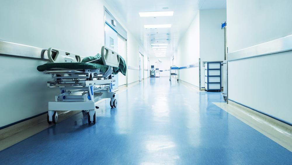 An Empty Hospital Hallway With A Stretcher In The Middle — Mall Medical Centre In Alice Springs, NT