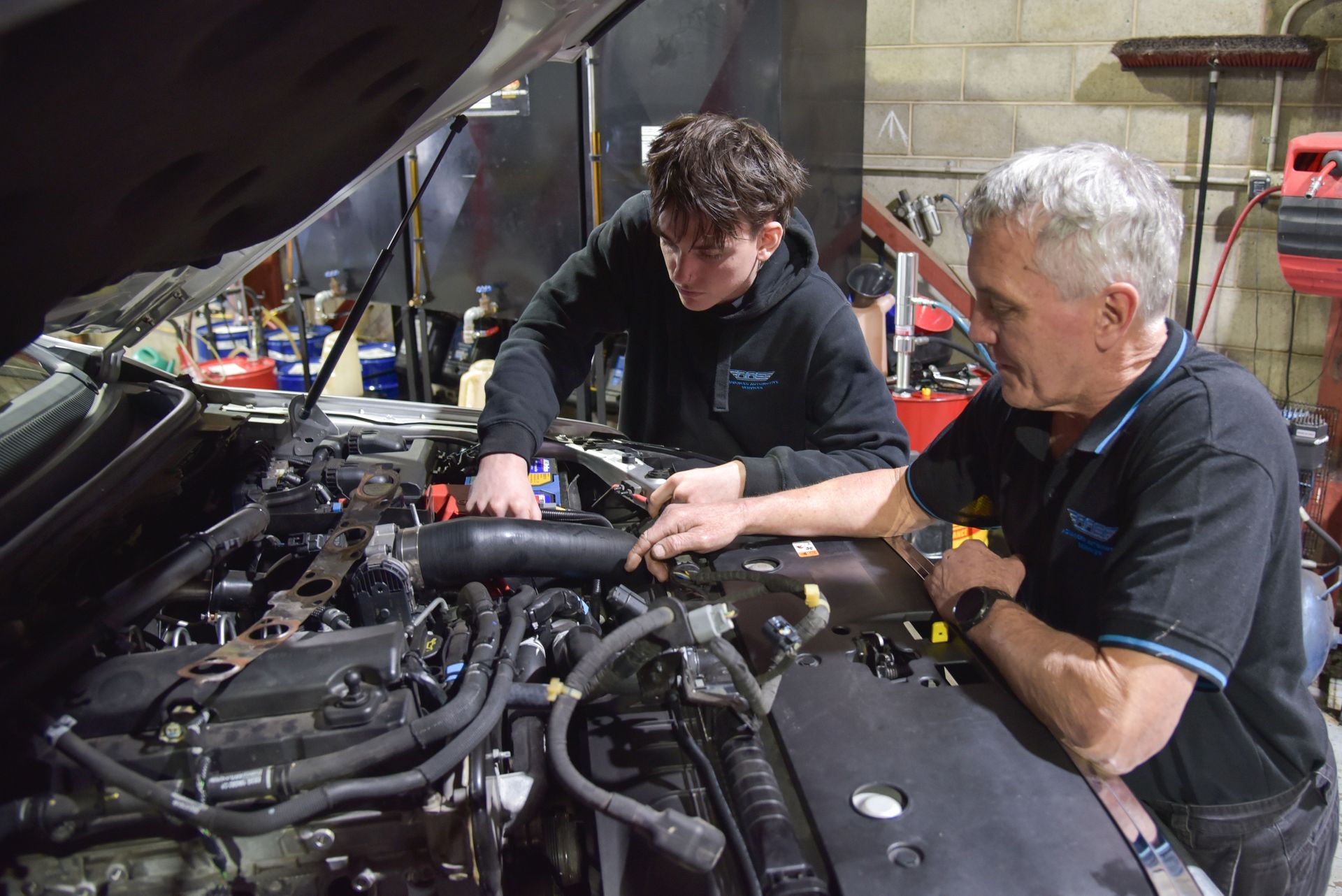 A man is looking inside the bonnet of a car — Advanced Automotive Services in Coffs Harbour, NSW