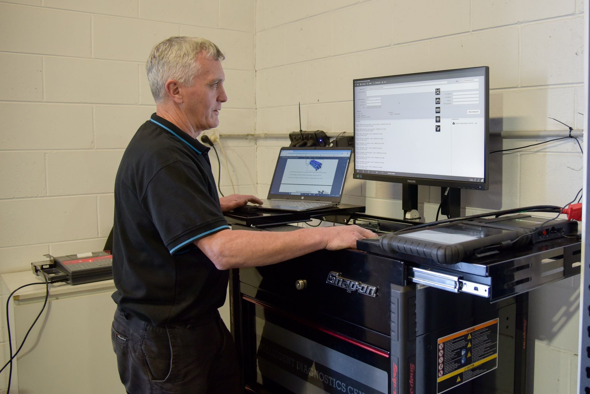 A man is standing at a large computer screen while running results on a car  — Advanced Automotive Services in Coffs Harbour, NSW