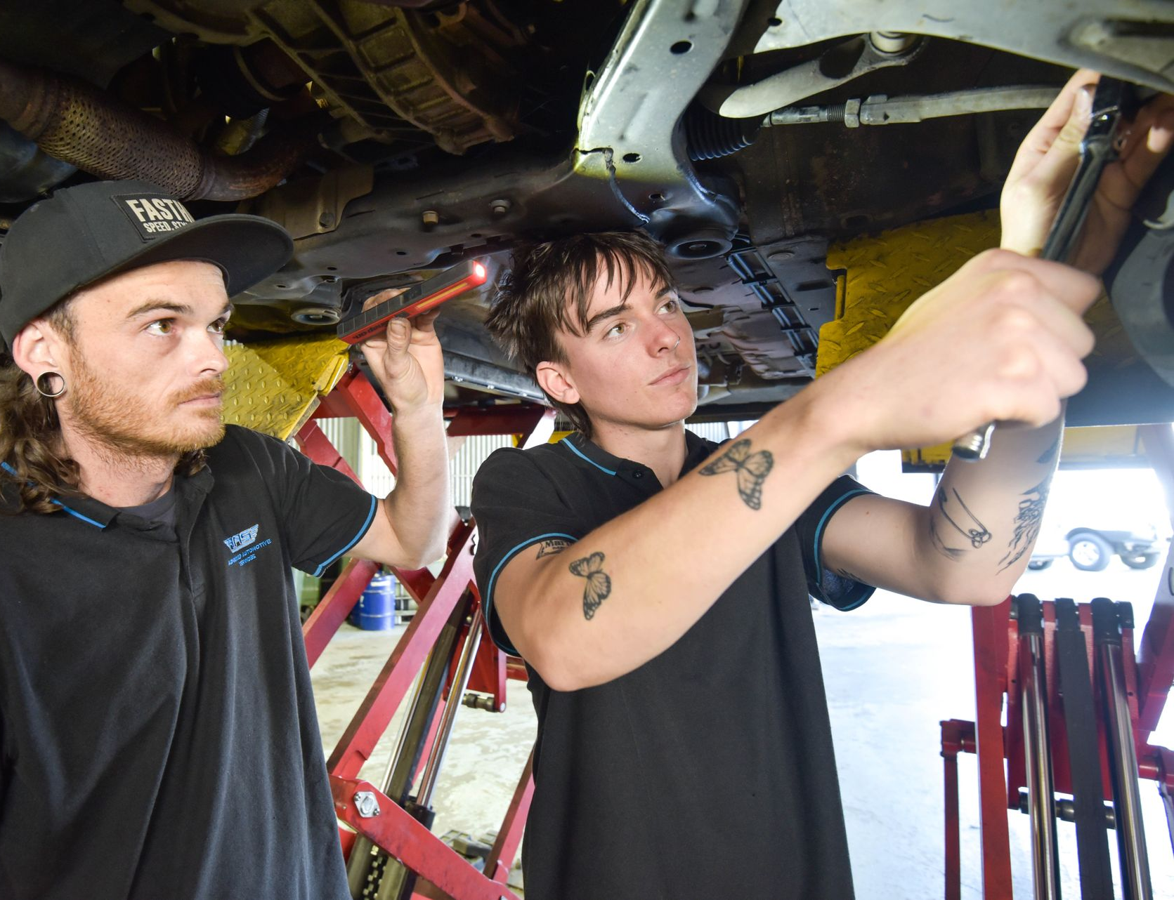 Two men are working under a car — Advanced Automotive Services in Coffs Harbour, NSW