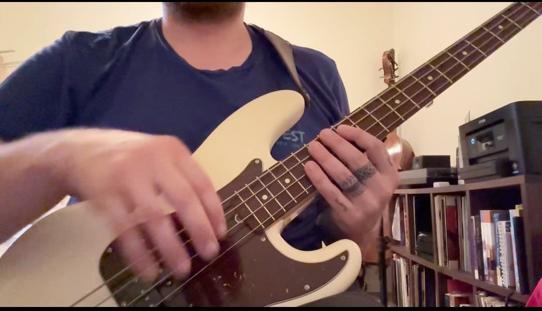 A man is playing an electric guitar in a living room.
