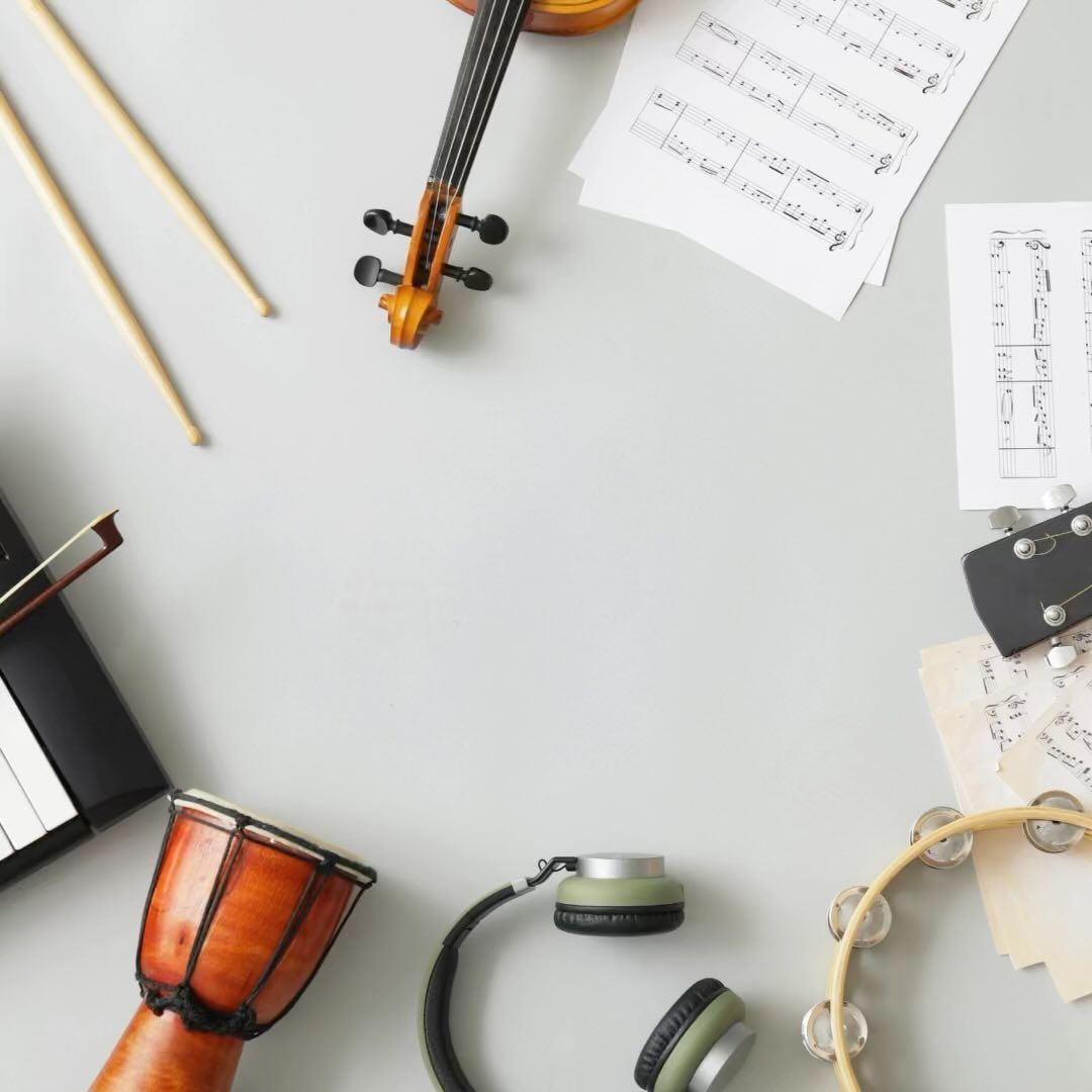 A violin is surrounded by other musical instruments on a table