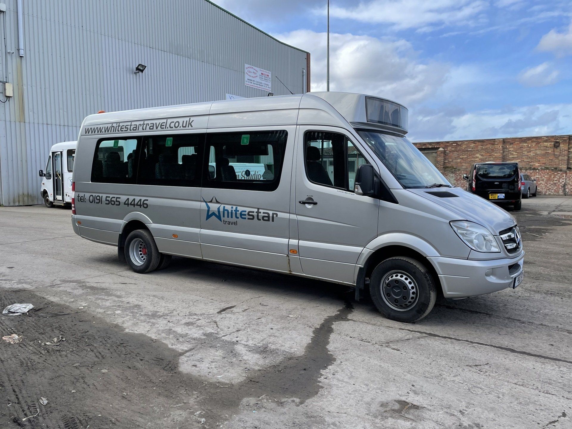 Silver passenger van parked outdoors; 