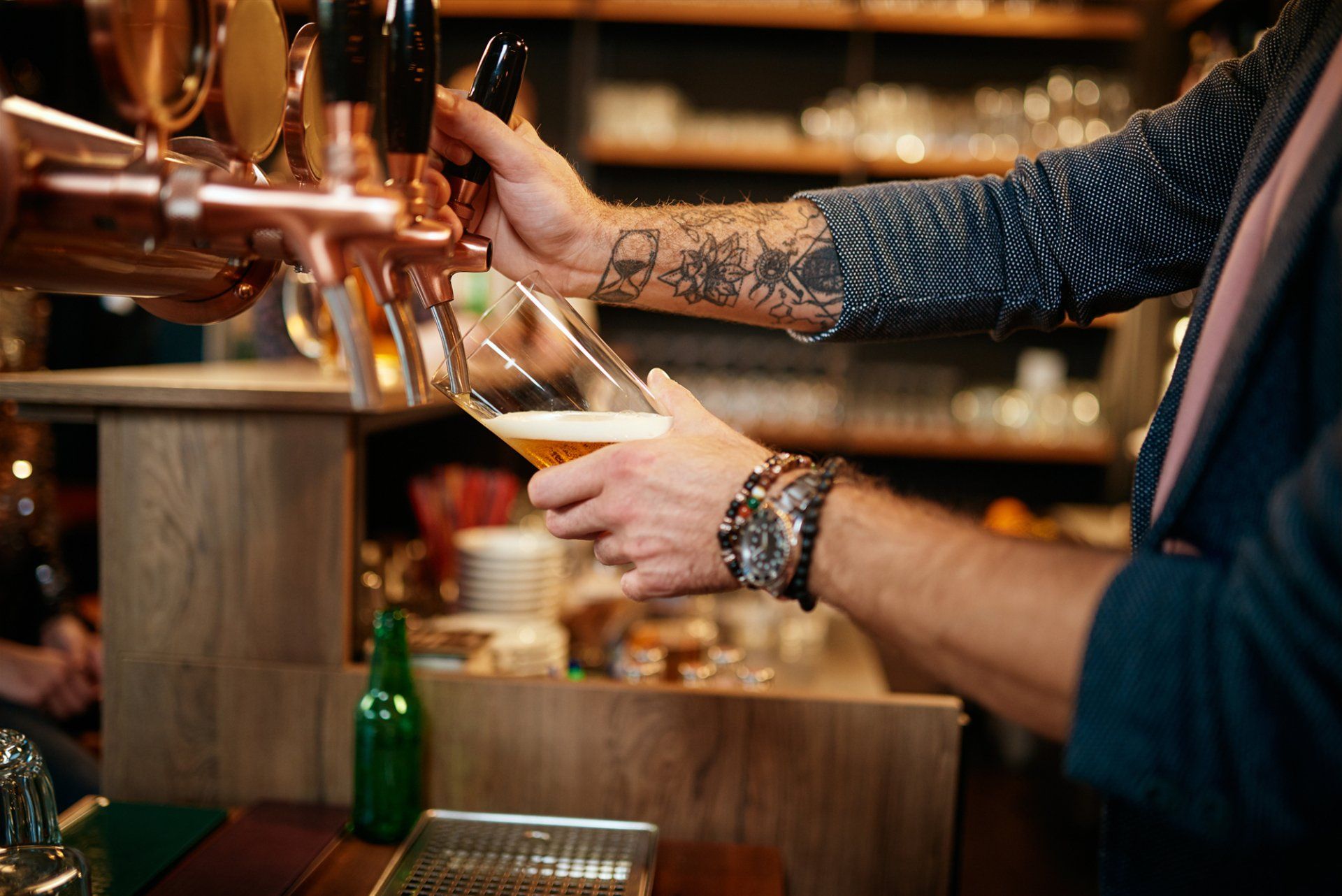 bartender pouring a beer from a beer tap