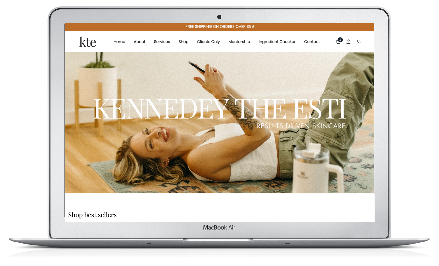 Laptop displaying a website with a woman lying on a mat, holding a pen, smiling.