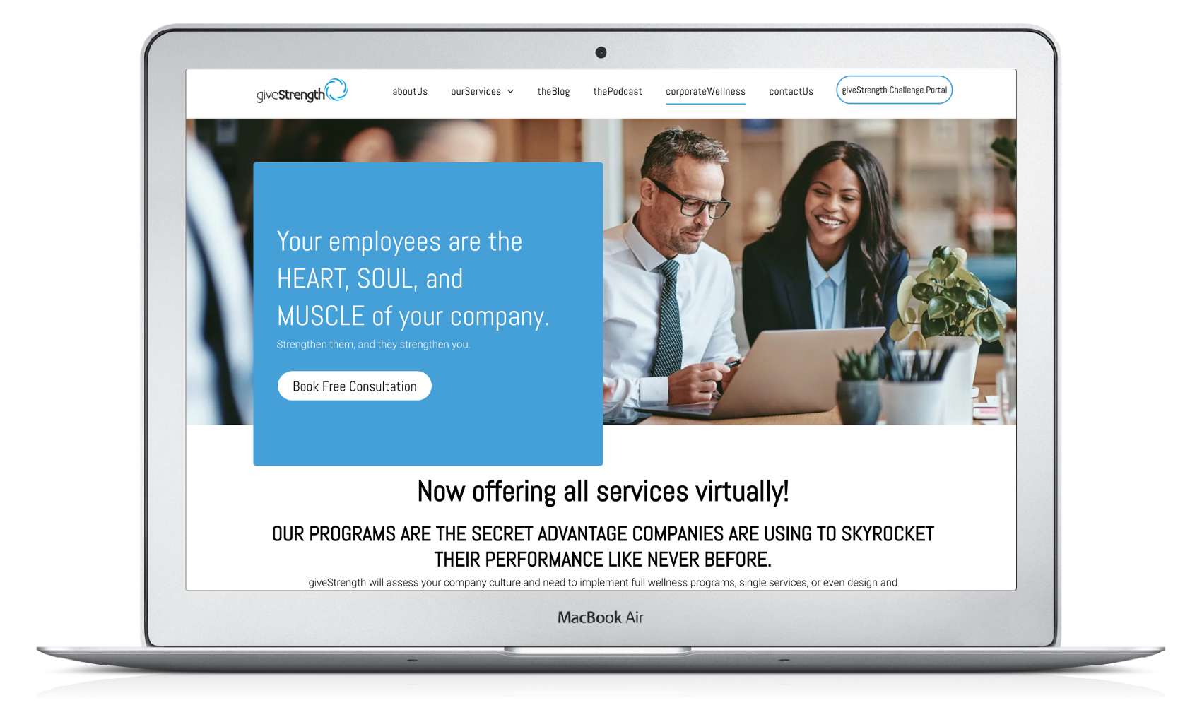 A man and a woman are sitting at a table looking at a laptop.