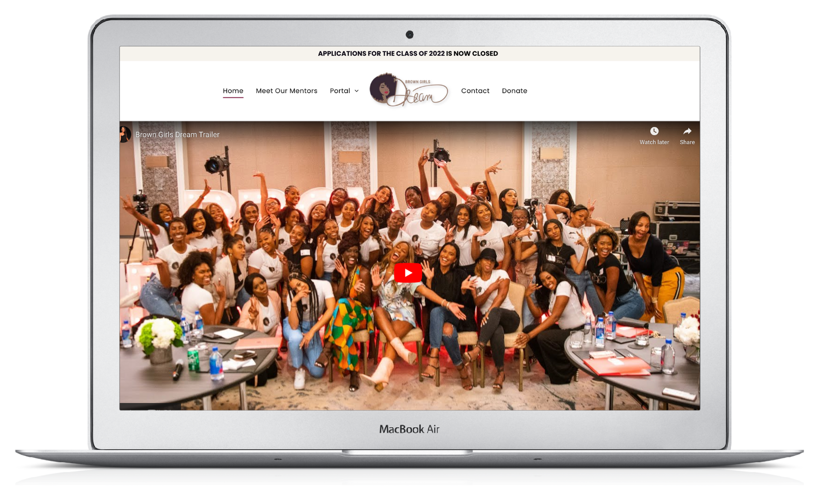 A group of people are posing for a picture on a laptop screen.