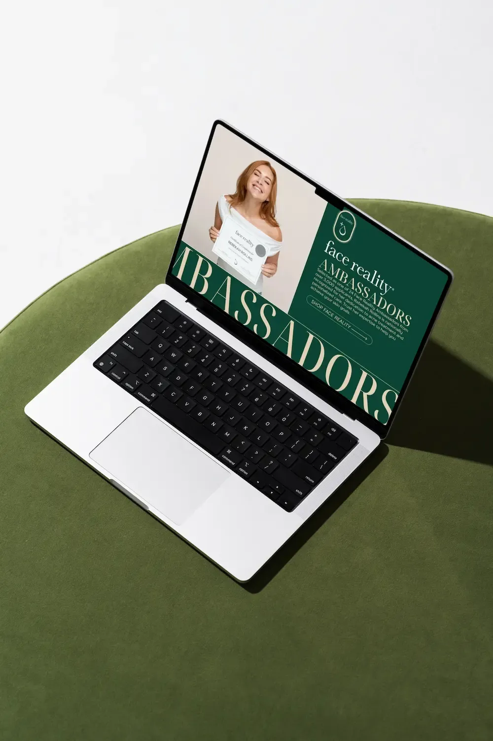 Laptop on green chair displaying a green-and-white “Ambassadors” presentation slide