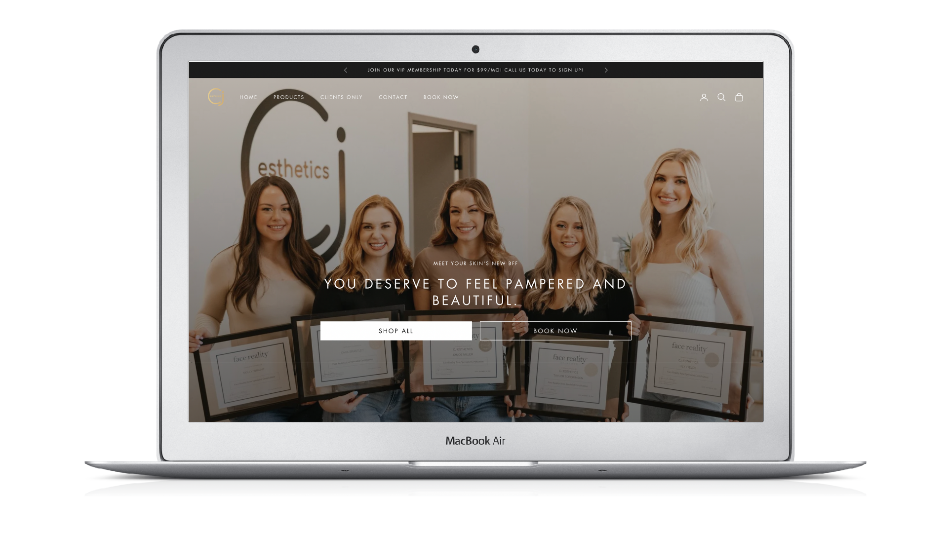 A laptop with a picture of a group of women holding certificates on the screen.