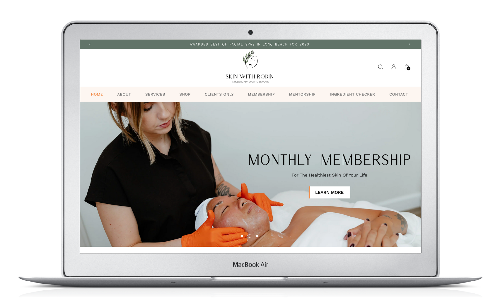 Laptop displaying a website with a woman holding orange yarn and a “monthly membership” banner