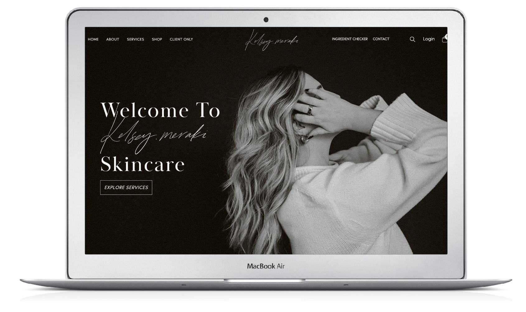 Laptop displaying a skincare website homepage. Woman in a sweater covers face.