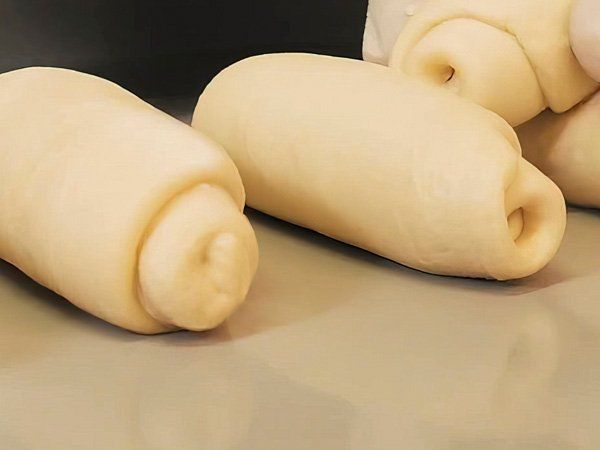 Hay tres rollos de masa sobre una mesa.