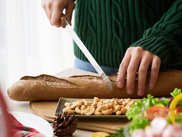pessoa cortando baguete