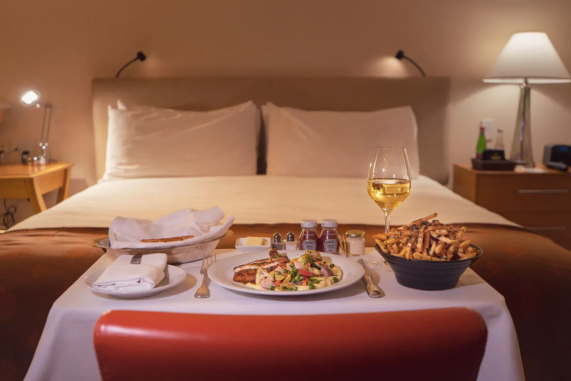 A Table With a Plate of Food and a Glass of Wine on It in a Hotel Room — Country Comfort Gin Gin Wild Scotsman Motor Inn in Gin Gin, QLD