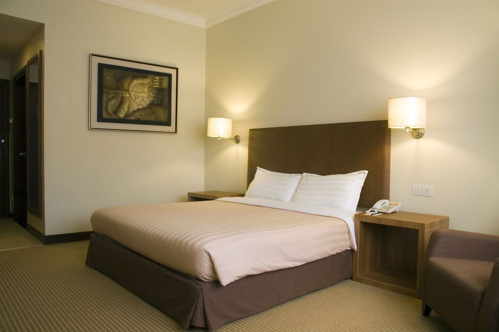 A Hotel Room With a Large Bed and a Chair — Country Comfort Gin Gin Wild Scotsman Motor Inn in Gin Gin, QLD