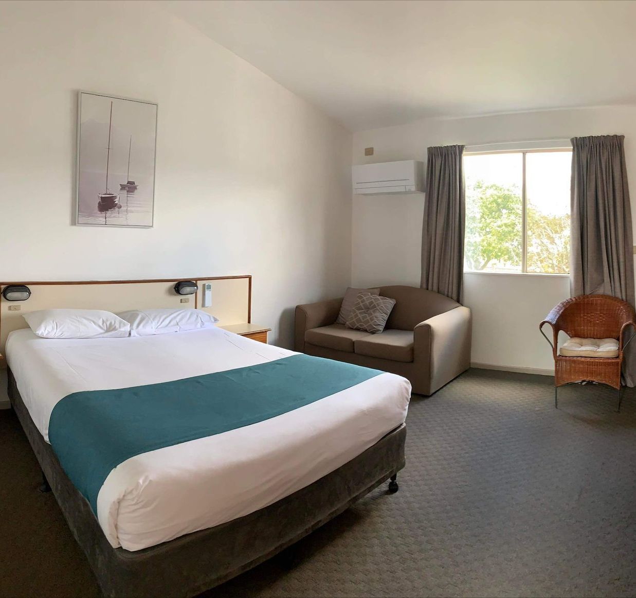 A Swimming Pool Surrounded by Palm Trees and Chairs — Country Comfort Gin Gin Wild Scotsman Motor Inn in Gin Gin, QLD