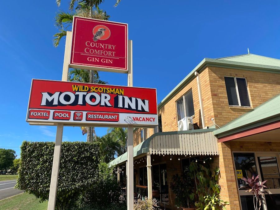 A Red Sign for a Motor Inn is in Front of a Brick Building — Country Comfort Gin Gin Wild Scotsman Motor Inn in Gin Gin, QLD