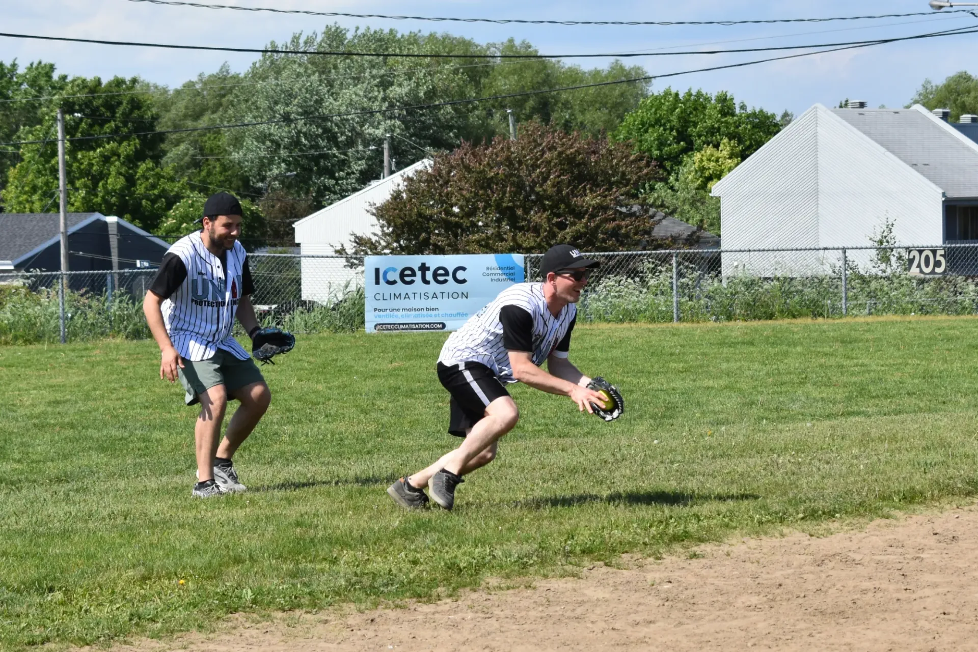 Deux joueurs au champs lors du tournoi de balle donnée qui attrapent la balle