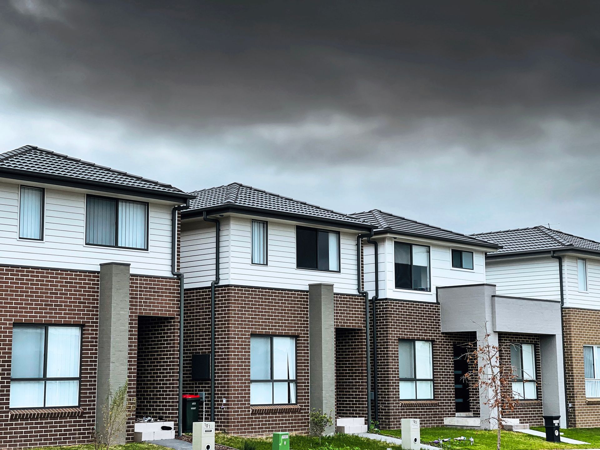 A row of houses with a cloudy sky in the background