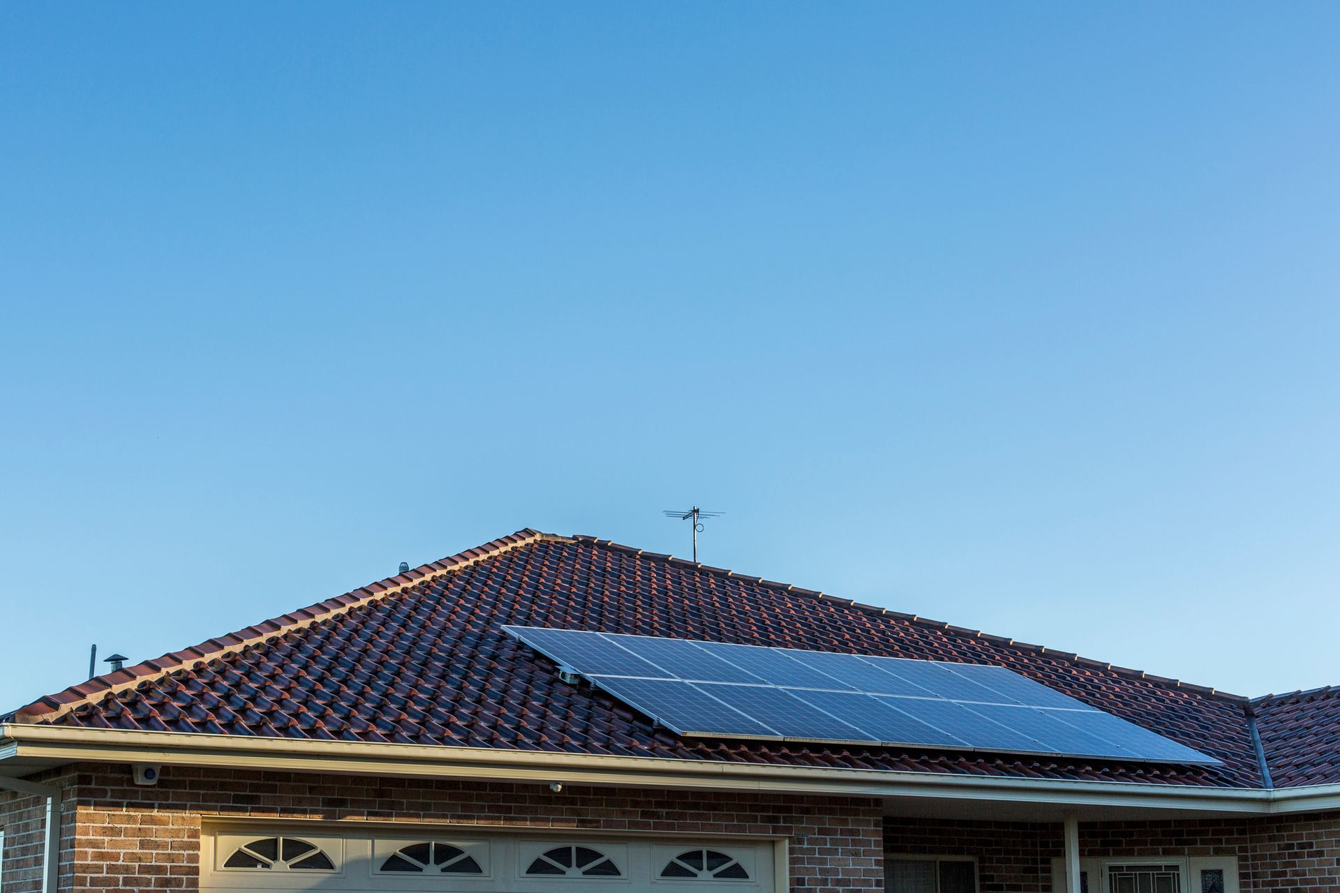 A house with solar panels on the roof and a garage door.