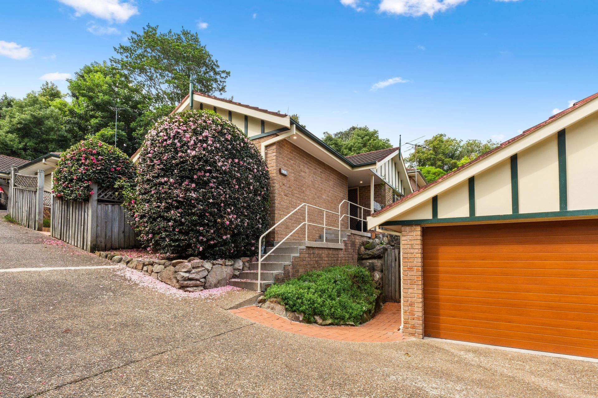 A house with a garage and stairs leading up to it.