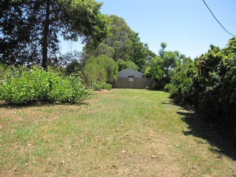 A fenced in yard with a house in the background