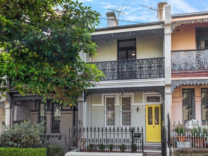 A row of houses with balconies and a yellow door.