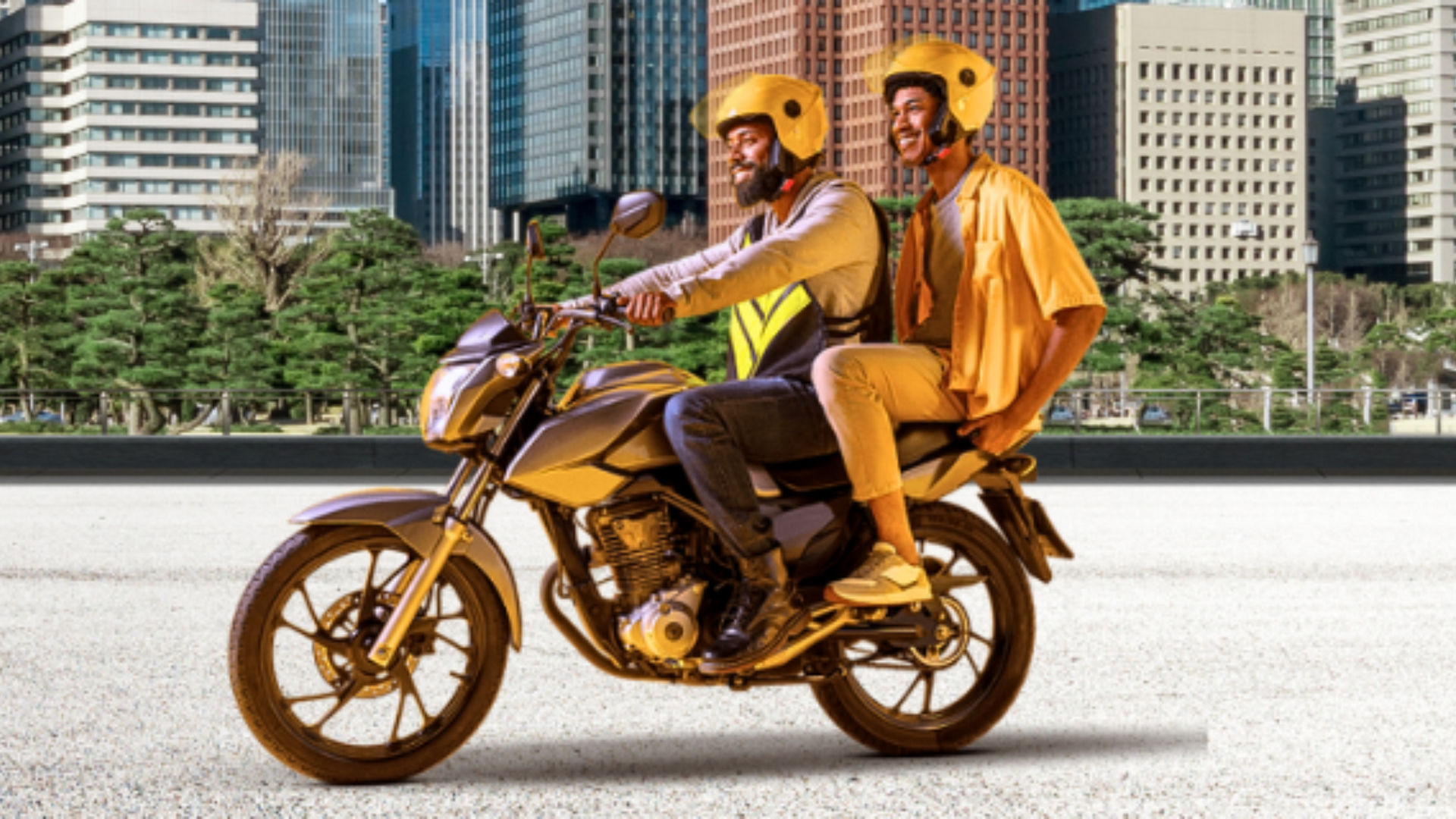 Duas pessoas andam de moto em uma rua da cidade.