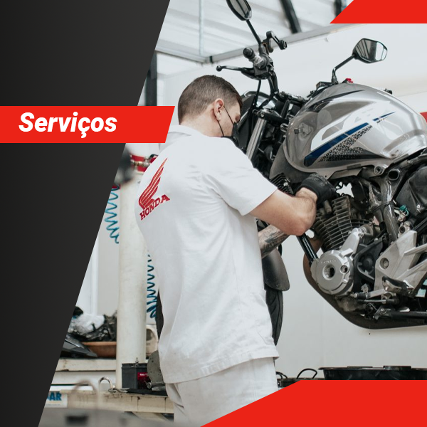 Um homem está trabalhando em uma motocicleta honda