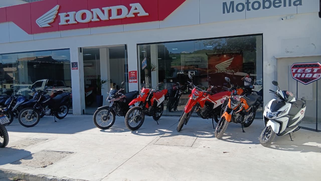 Honda motorcycle dealership storefront with several parked motorcycles outside, including red, black, and white bikes.