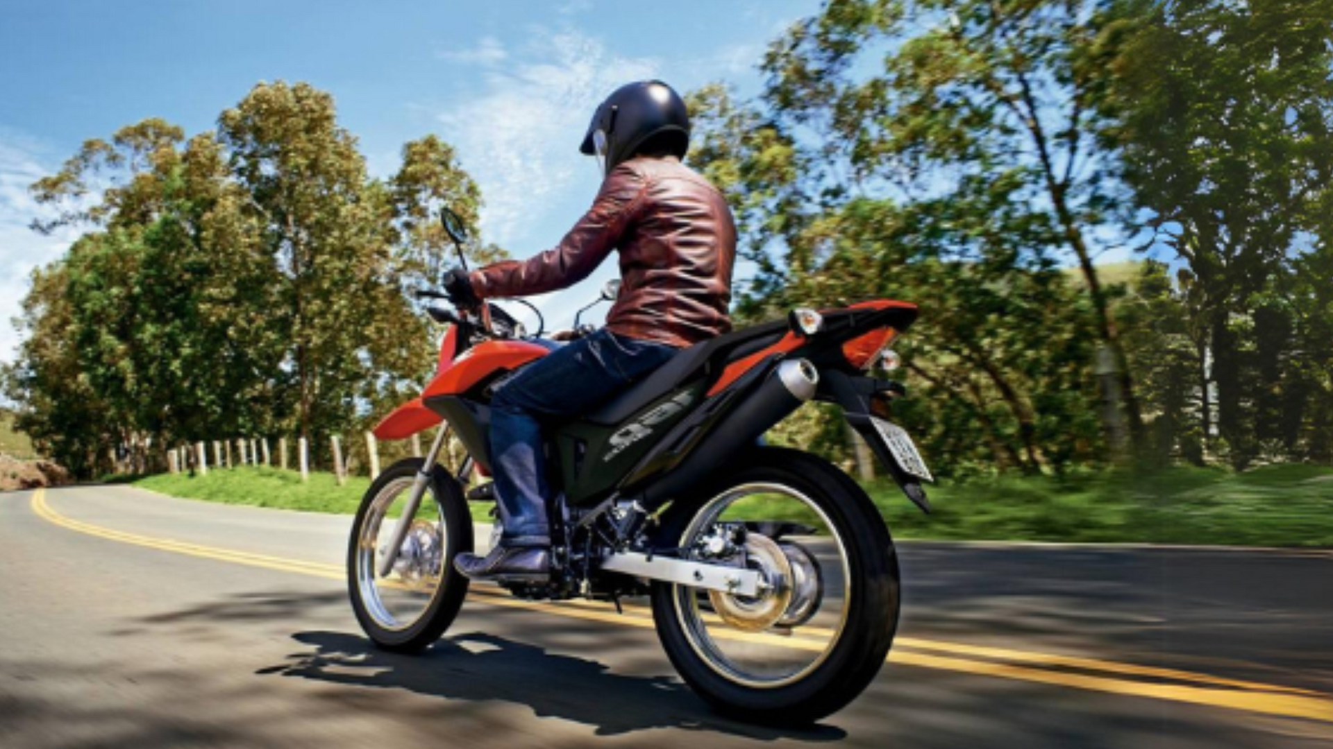 Um homem está andando de moto por uma estrada.
