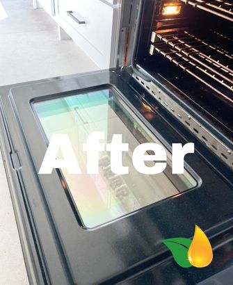After view of a black oven door with a glass window, showing the interior rack and a green-yellow leaf logo.