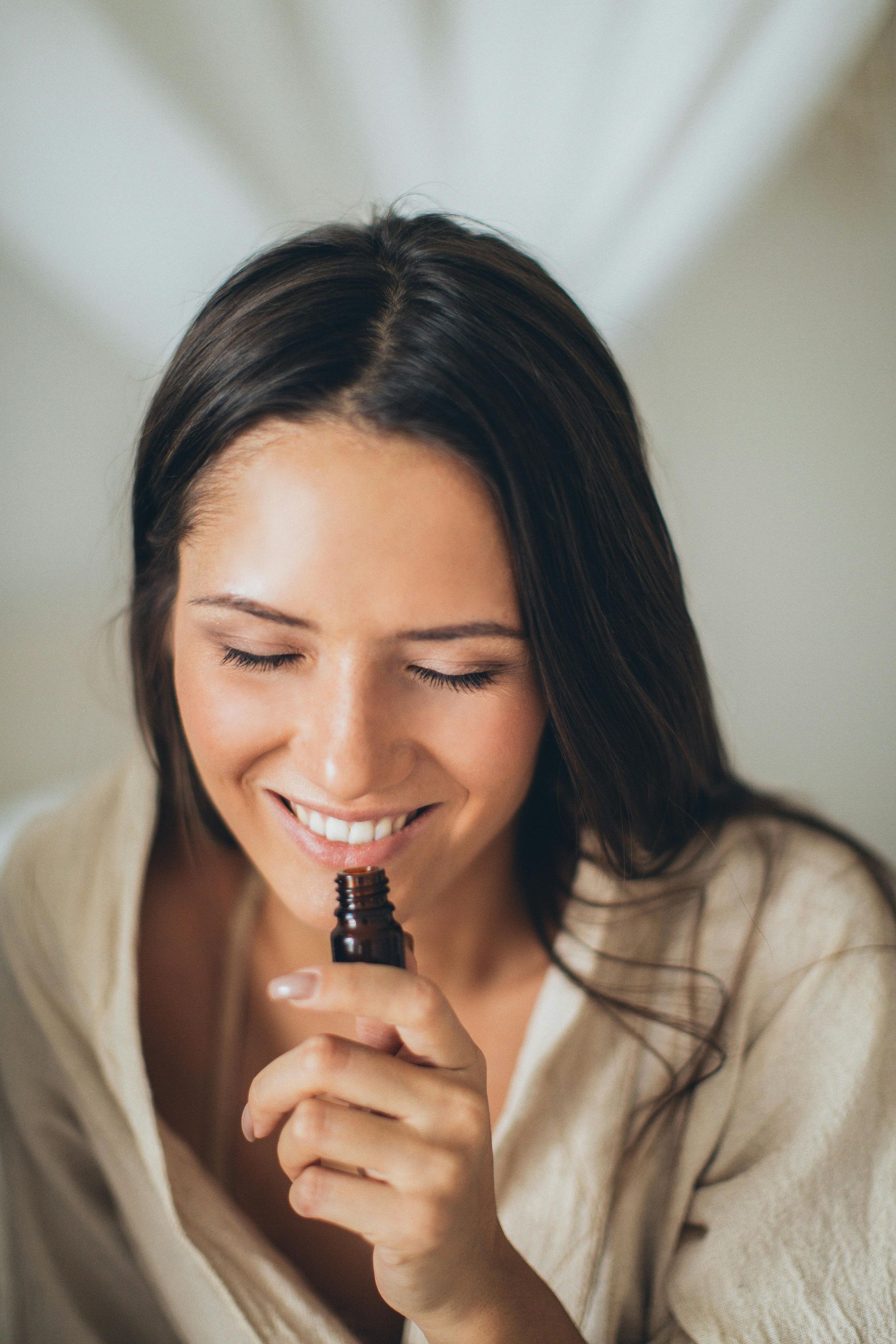 Woman smelling essential oil used in natural home cleaning services