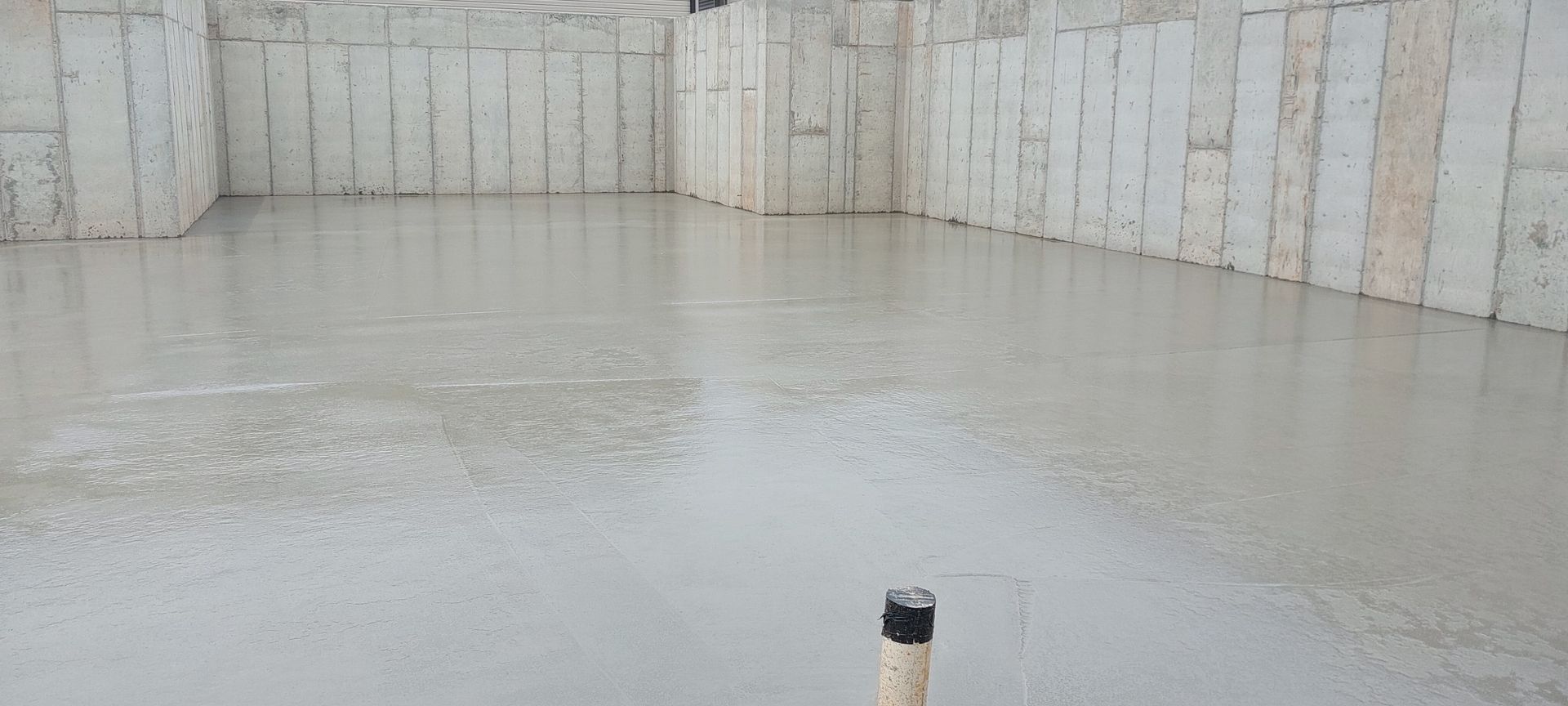A concrete floor with a pipe in the middle of it.