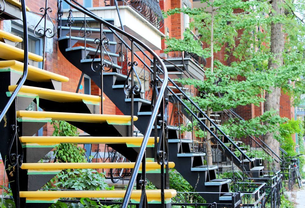 Un ensemble d'escaliers noirs et jaunes menant à un bâtiment en brique.