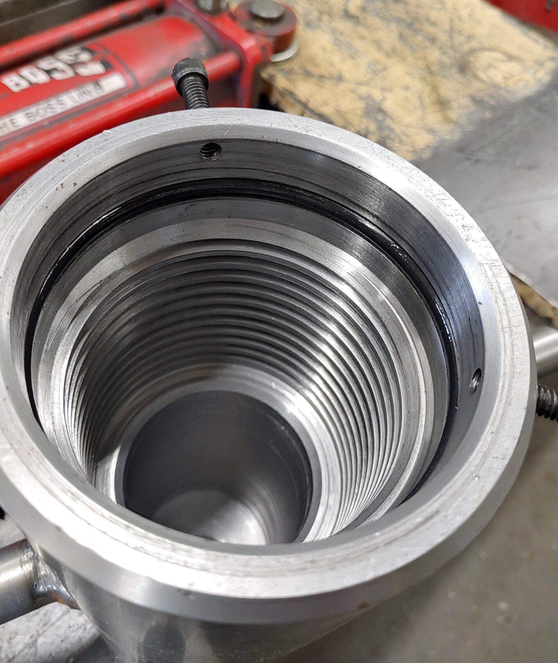 Open, threaded metal cylinder; possibly a bike frame component. Black o-rings visible inside.