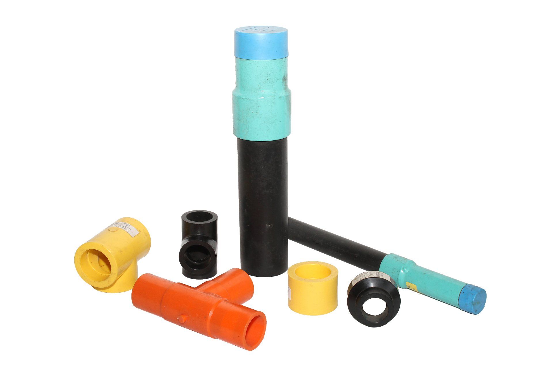 Assortment of colored plastic plumbing pipes and fittings against a white background.