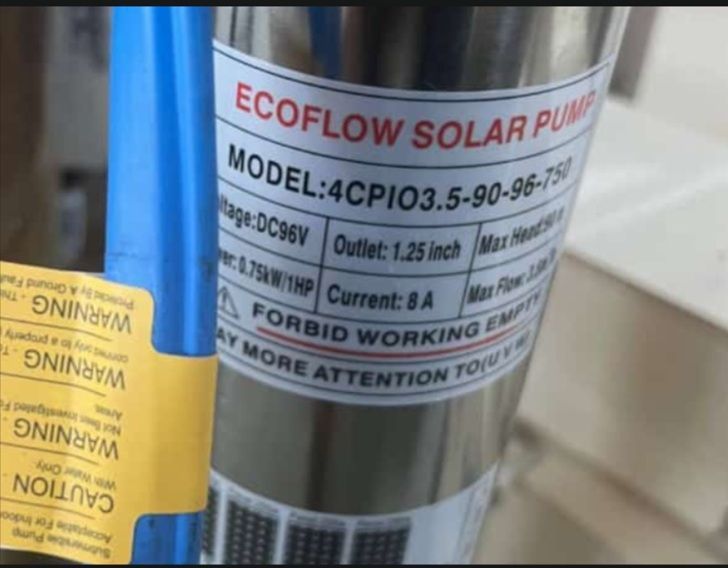 Close-up of an EcoFlow solar pump label on a metal cylinder, with a yellow warning tag beside it