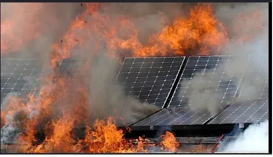 Solar panels engulfed in flames and smoke.