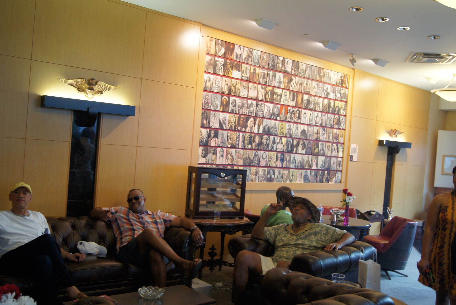 People sitting on couches in a warmly lit living room with wall art and a TV.