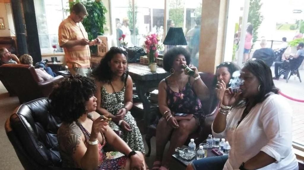 Group of people chatting on a couch in a bright living room, with snacks on the coffee table.