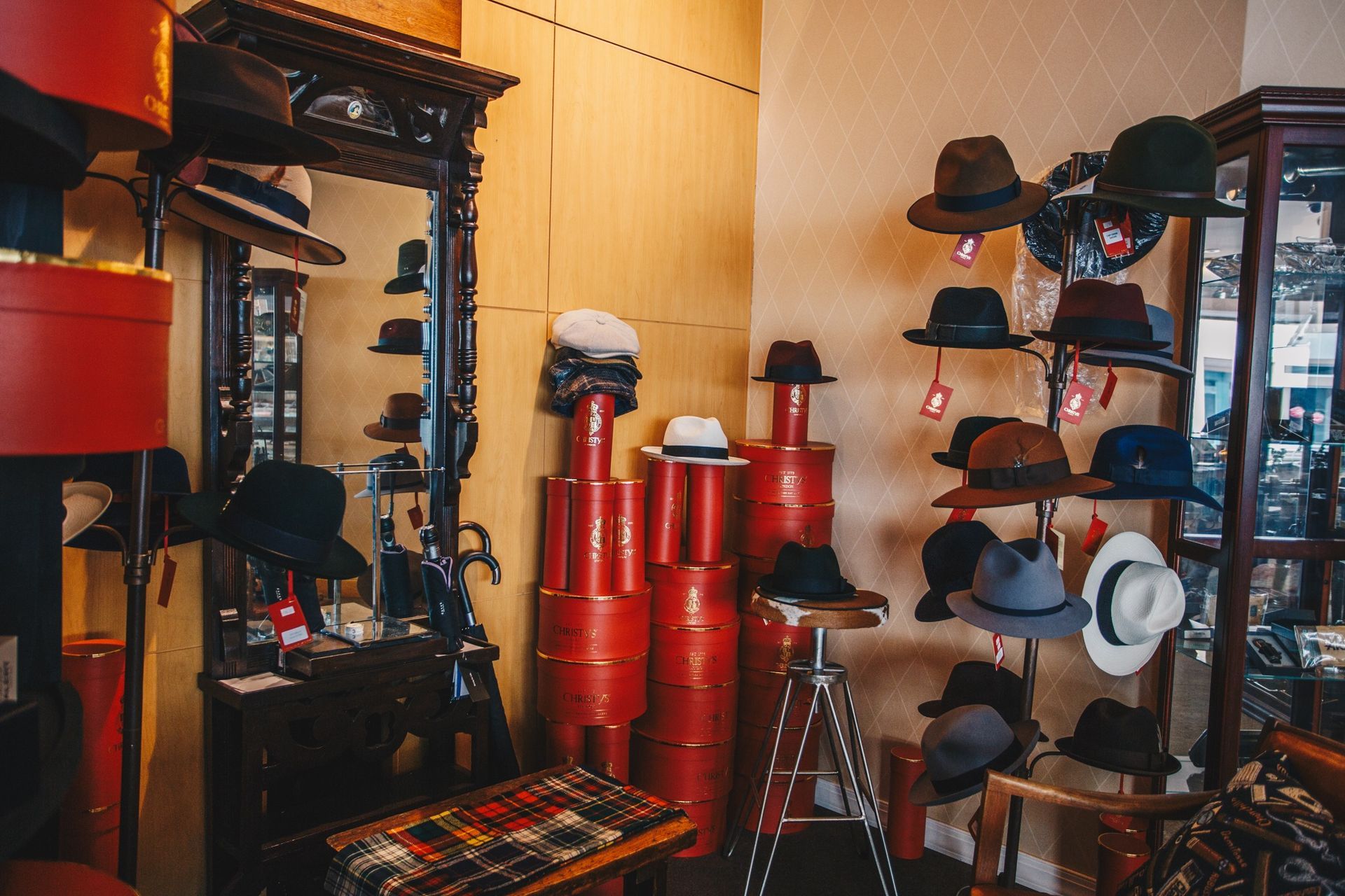 Hat and costume shop with racks of red, black, and gray hats and accessories.