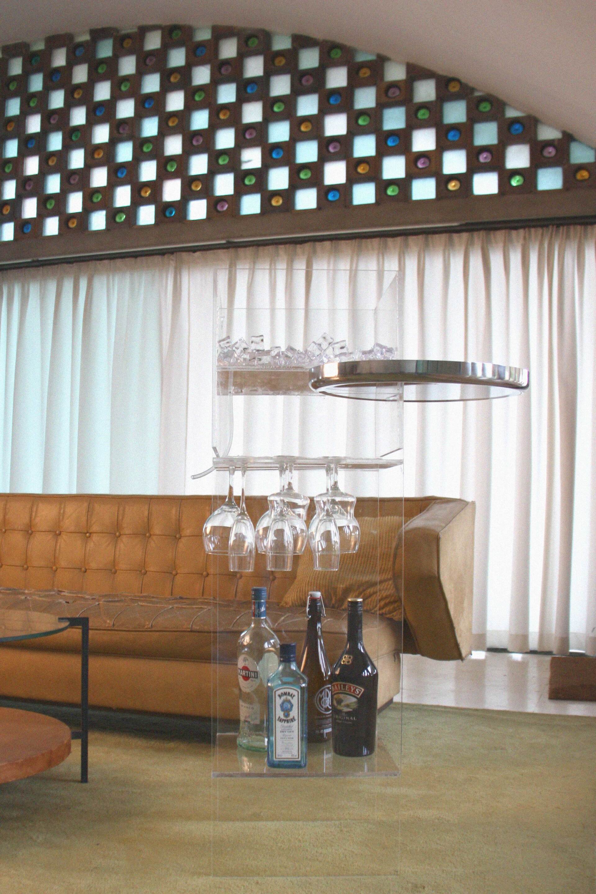Interior de La Ricarda al Prat de Llobregat dissenyat per Mersi Studio. Moble de metacrilat transparent amb bestil art deco.