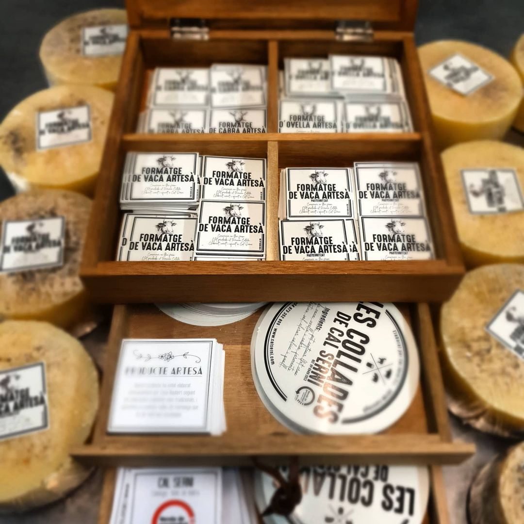 Una caja de madera llena de diferentes tipos de queso. Mersi Studio