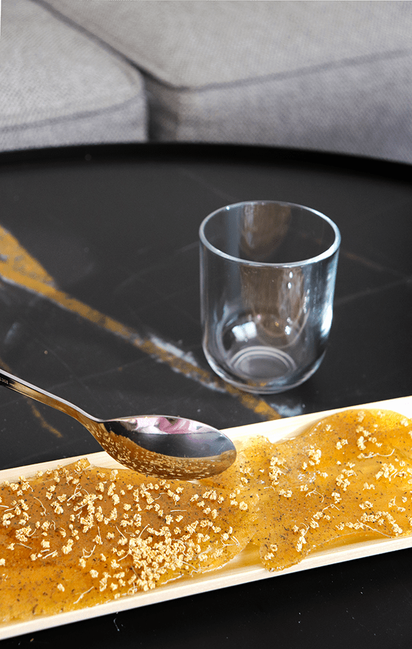 Un plato de comida con una cuchara y un vaso sobre una mesa. Mersi Studio