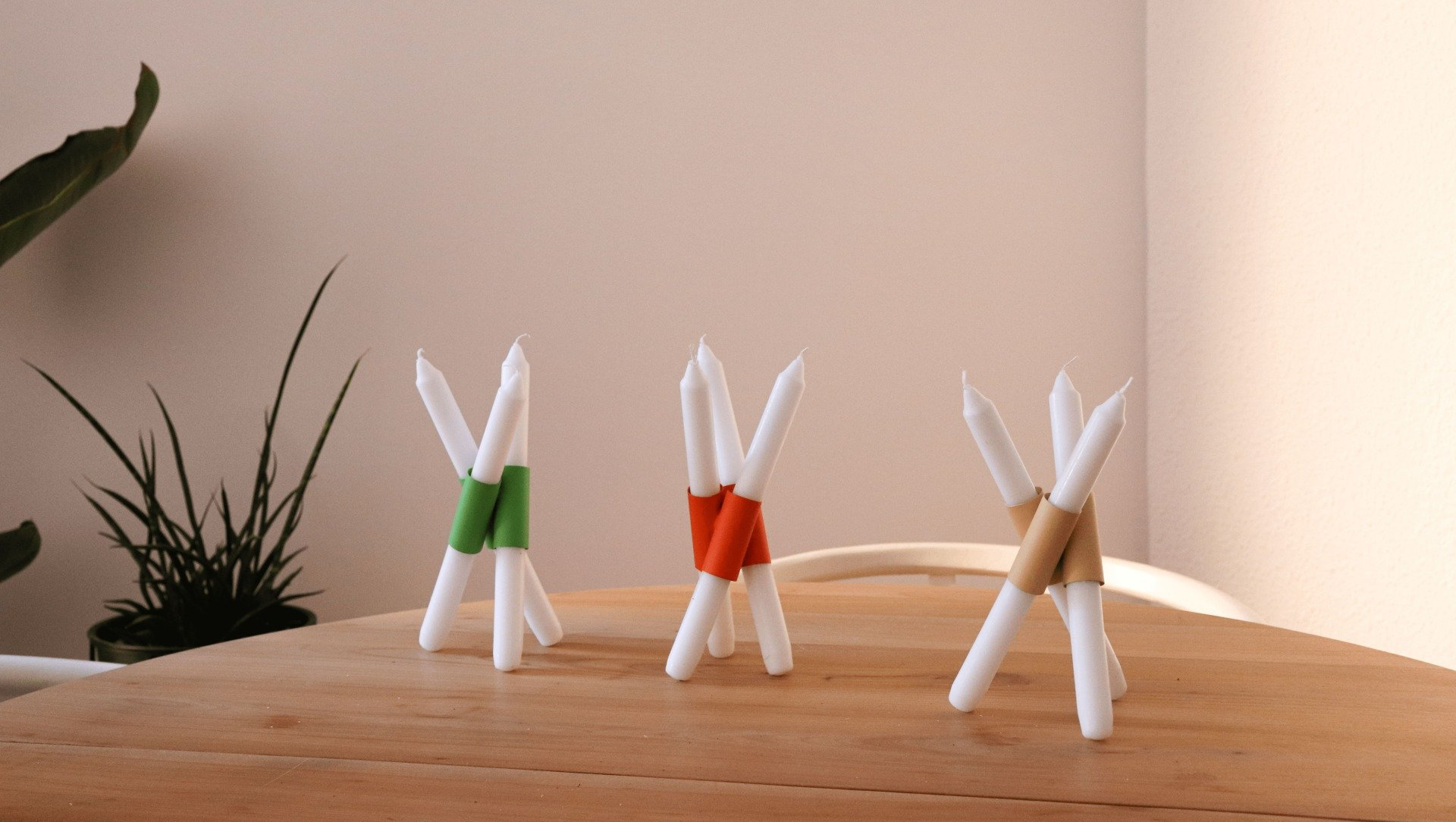 Hay tres velas sobre una mesa de madera.Mersi Studio